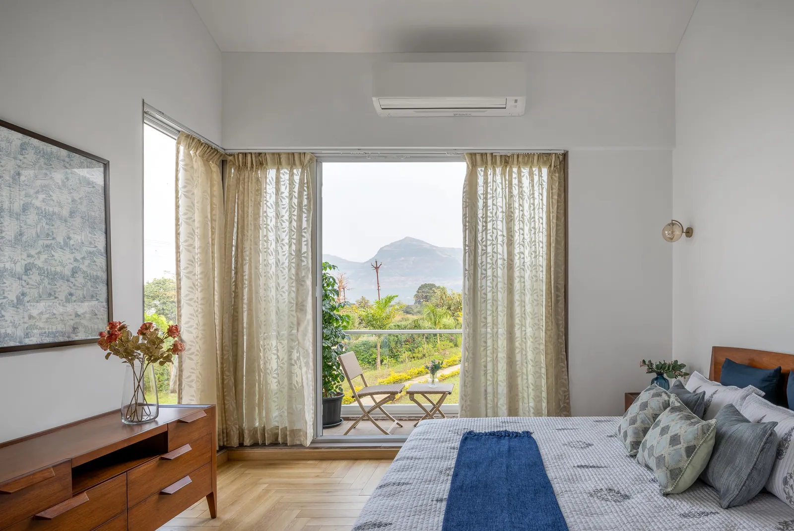 Bedroom opening to a balcony with a view of the hills